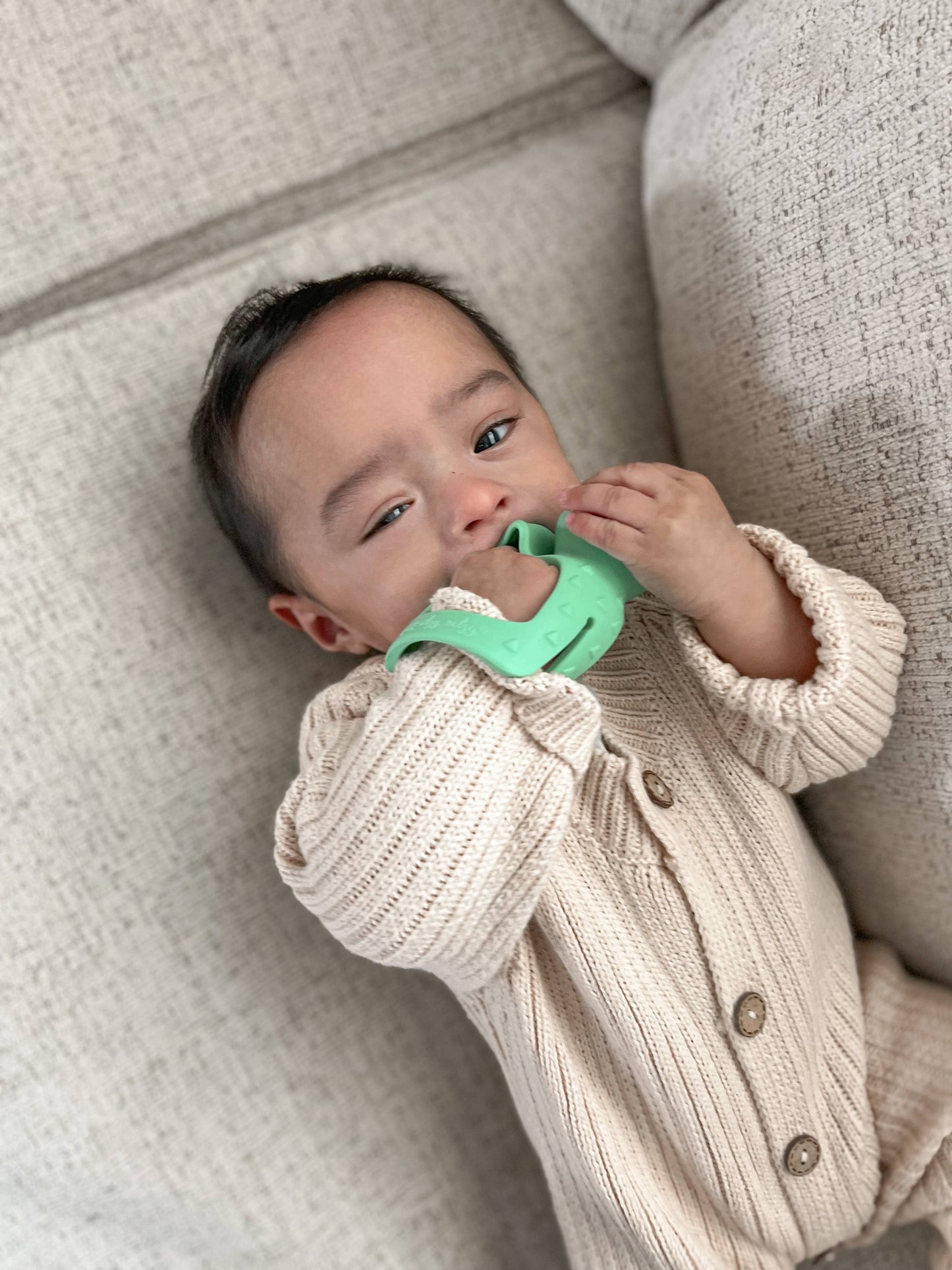 Baby teething on Green Dinosaur baby teether with grip bar