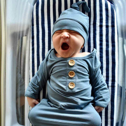 Baby in a blue outfit with button details