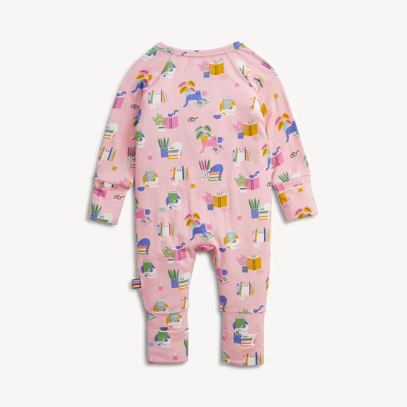 A baby long-sleeve footless one-piece jumpsuit in light pink, featuring an all-over colorful cartoon print of unicorns, books, plants, and gift boxes, shown against a plain off-white background.