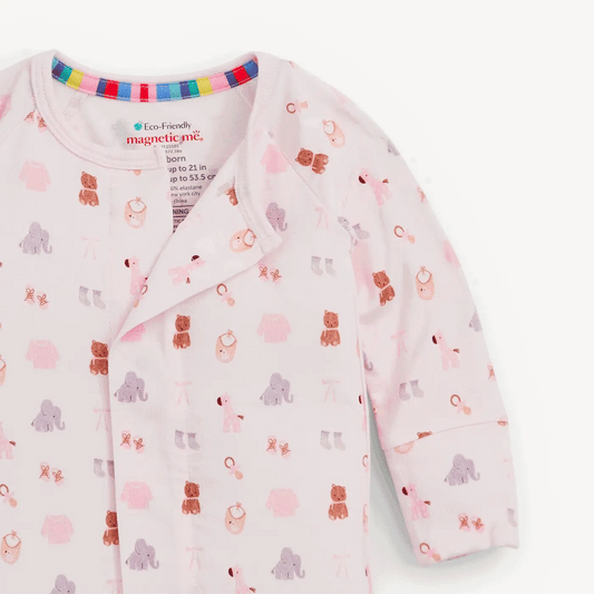 A light pink long-sleeve baby sleep sack with an all-over animal print of bears, elephants, and lions in soft pastel colors. It features a colorful striped inner collar and a visible 'magnetic mic' brand label inside the neckline.