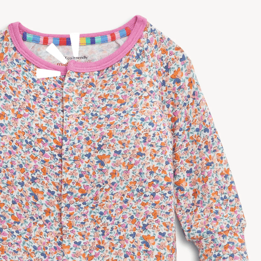 A close-up of a long-sleeve children's top with a dense multicolor butterfly print on a white base, featuring a pink ribbed collar and a colorful striped inner neck trim.