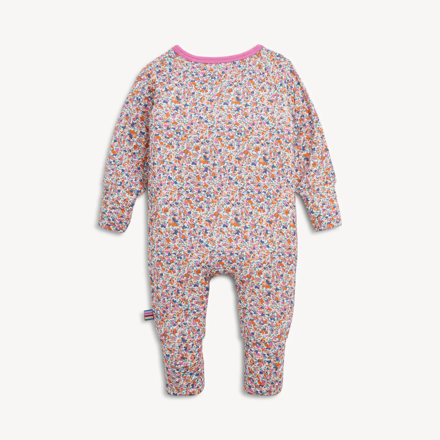 A baby long-sleeve footless one-piece jumpsuit with a dense multicolor floral print on a light pinkish-beige background, featuring a contrasting pink collar.