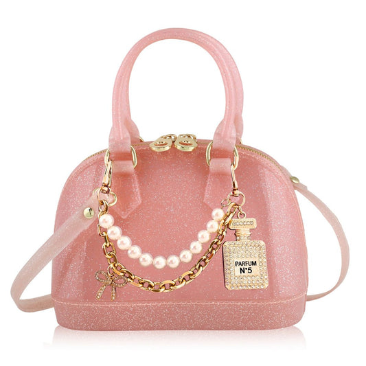 Pink handbag with a charm featuring a perfume bottle and pearls 