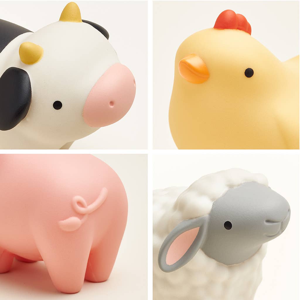 Four animal figurines including a cow, chicken, pig, and sheep on a white background.
