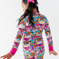 Child wearing a colorful onesie with cartoon designs on a white background