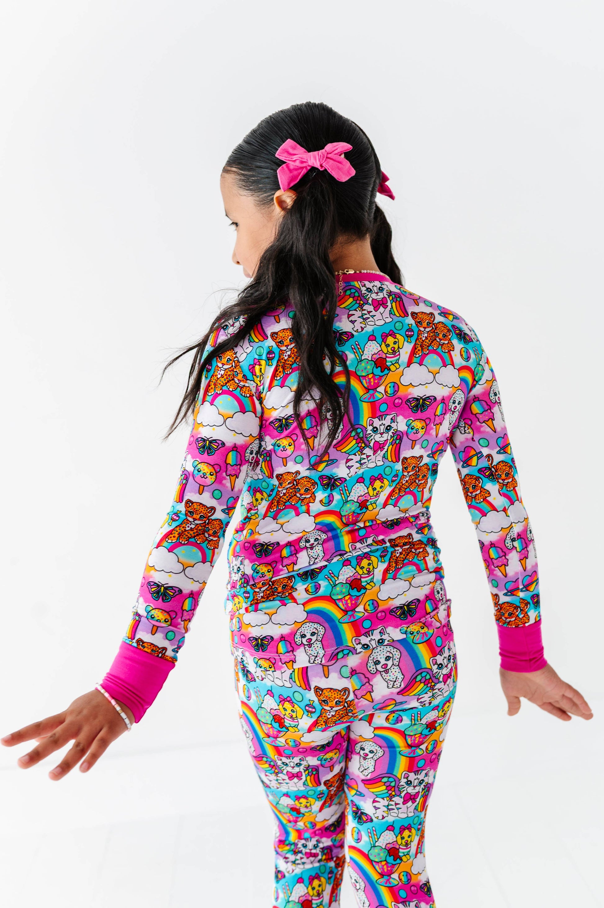 Child wearing a colorful onesie with cartoon designs on a white background