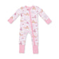 A baby's long-sleeve footed sleeper in light pink, featuring a whimsical print of castles, carriages, and balloons, with solid pink cuffs and a pink zipper.