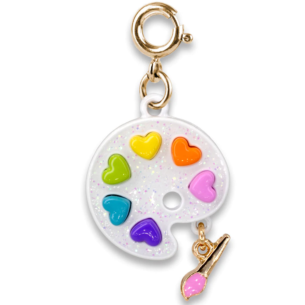 A jewelry charm featuring a palette with colorful heart-shaped compartments and a small paintbrush, primarily in gold and multicolor tones.