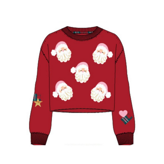 A red long-sleeve cropped sweater with an all-over Santa Claus face pattern, ribbed crew neck, cuffs, and hem, plus small holiday-themed patches on both sleeves, shown on a plain white background.