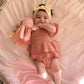 Baby holding pink bunny toy