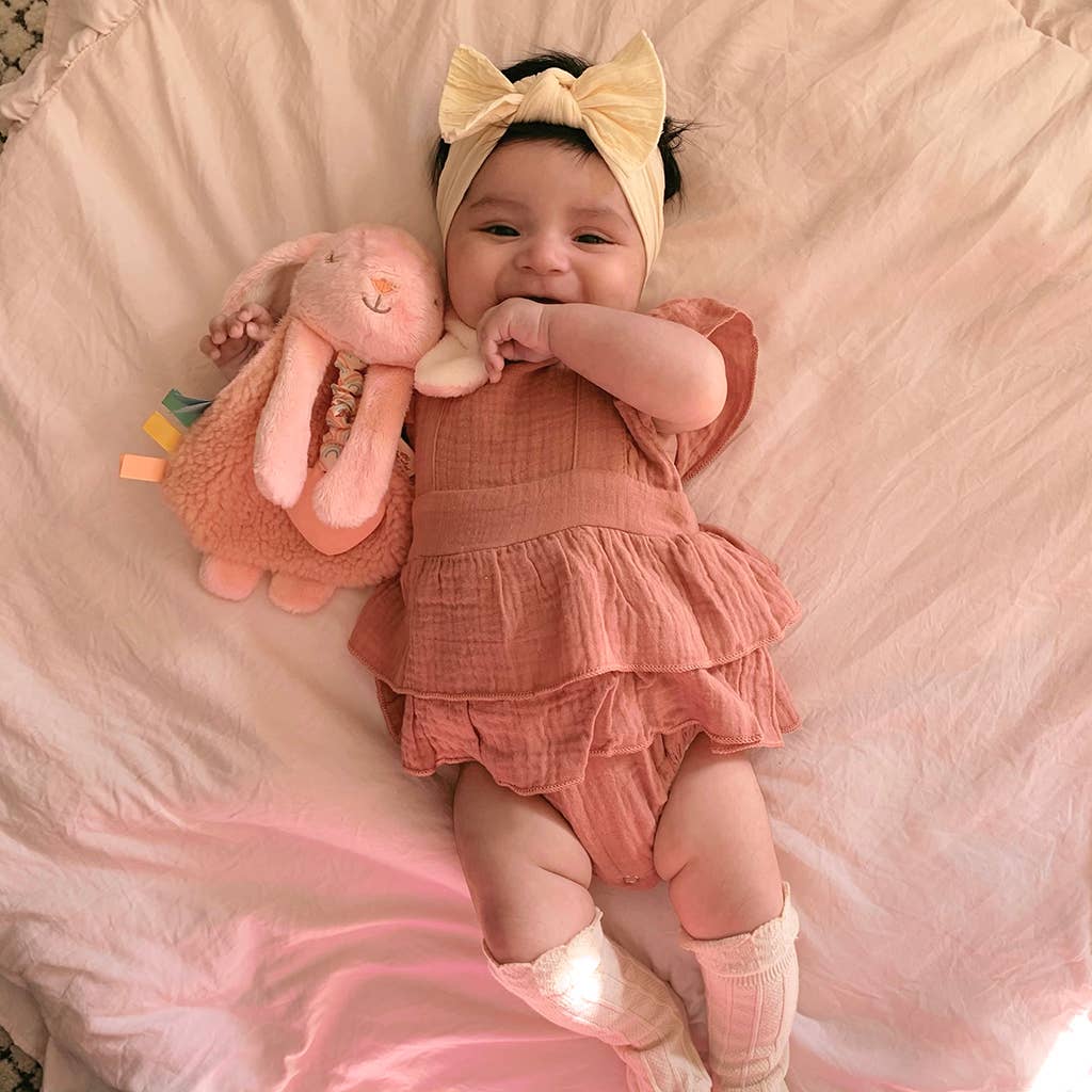 Baby holding pink bunny toy