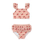 Pink two-piece swimsuit with cherry pattern on a white background