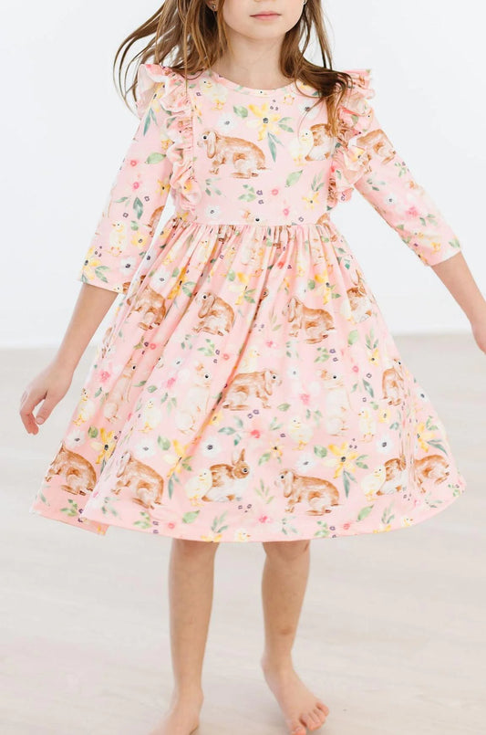 pink ruffle twirl dress with a floral and animal pattern, featuring a scoop back and ballet neckline.