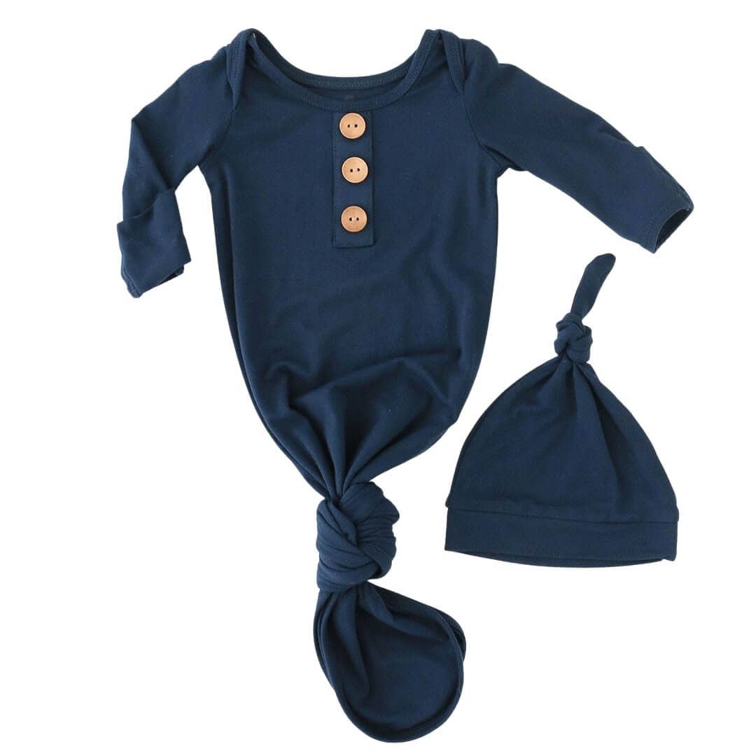 Navy blue baby onesie with button details and matching knot hat