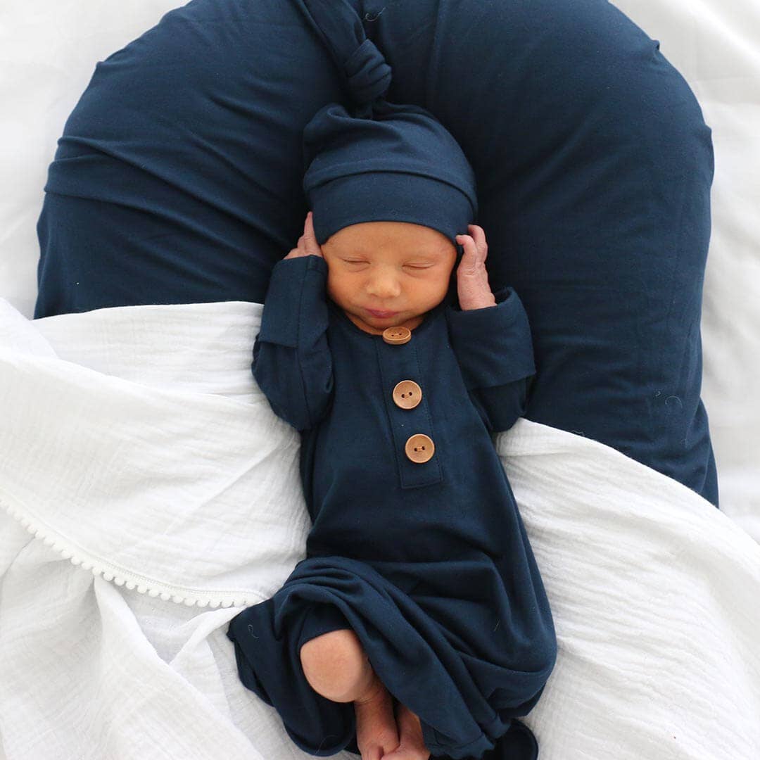 Newborn baby in a navy outfit with buttons
