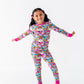 Child wearing a colorful unicorn-themed onesie on a white background