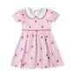 Pink dress with apple details.
