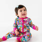 Child wearing a colorful onesie with cartoon characters on a white background