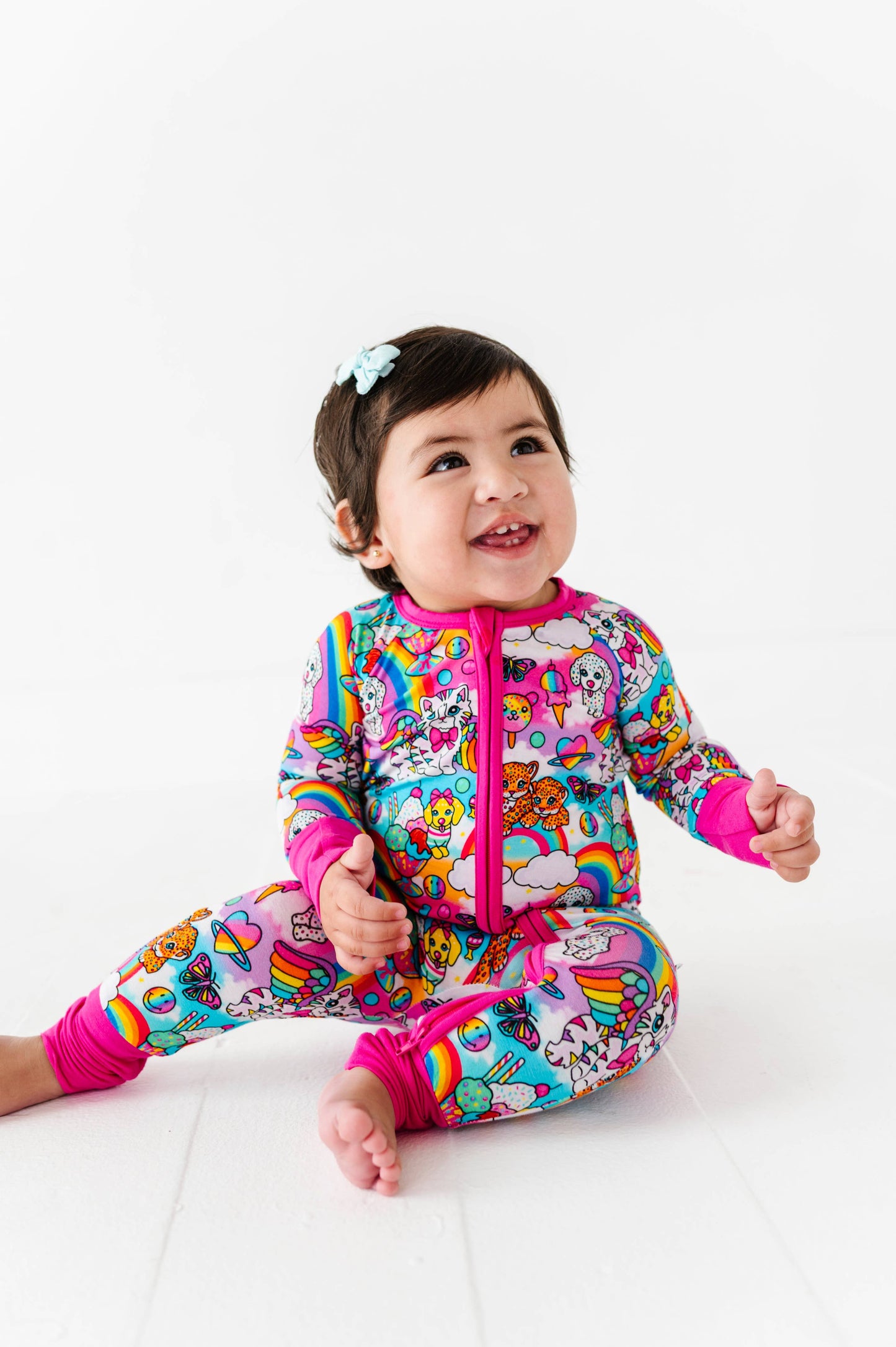 Child wearing a colorful onesie with cartoon characters on a white background