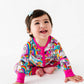 Child wearing a colorful jacket with cartoon designs on a white background