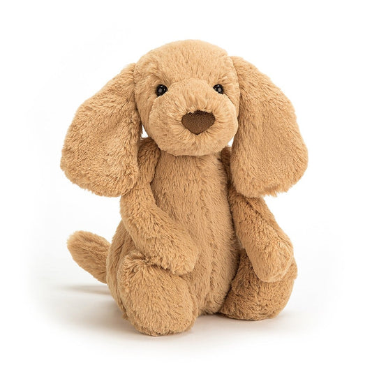 A plush toy resembling a golden retriever puppy with soft brown coloring and long ears.