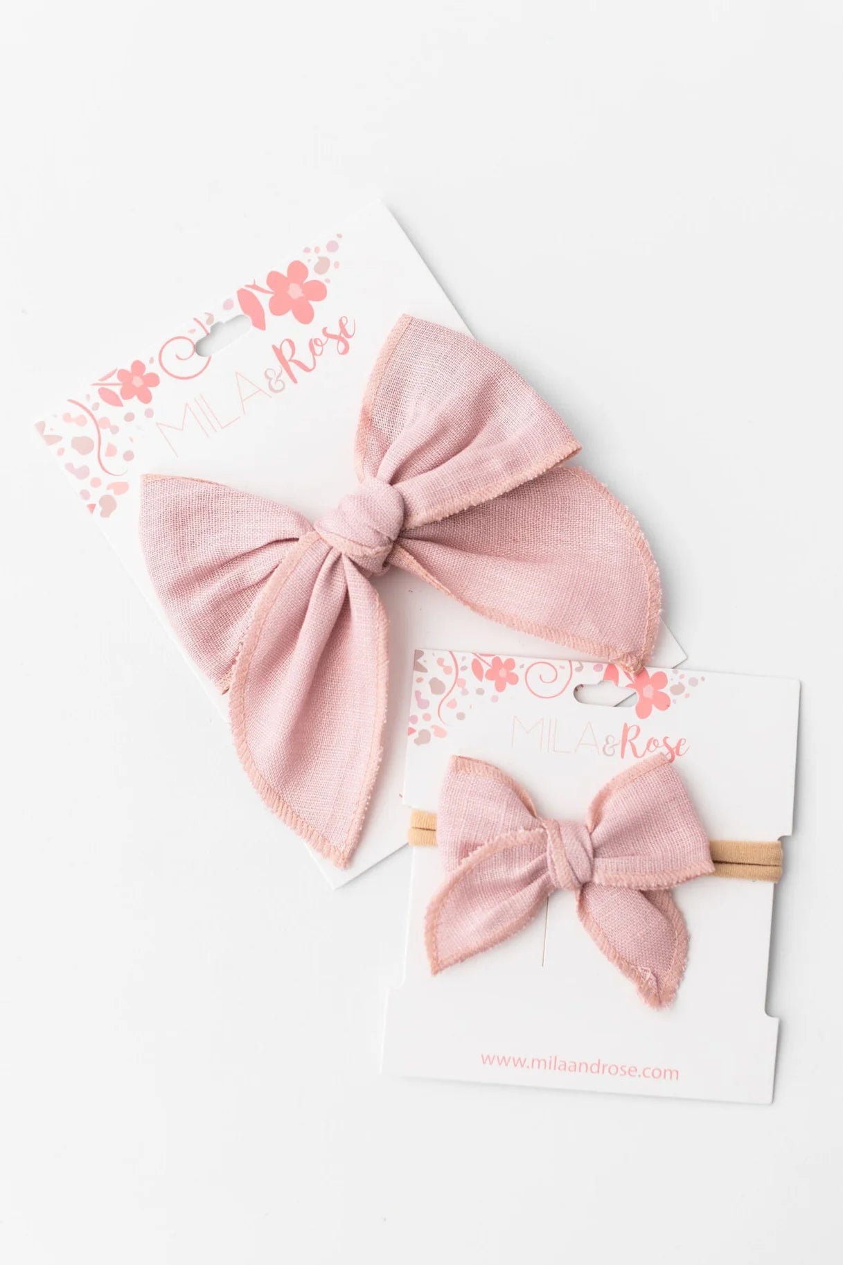 Pink bow headbands on a white card with floral design