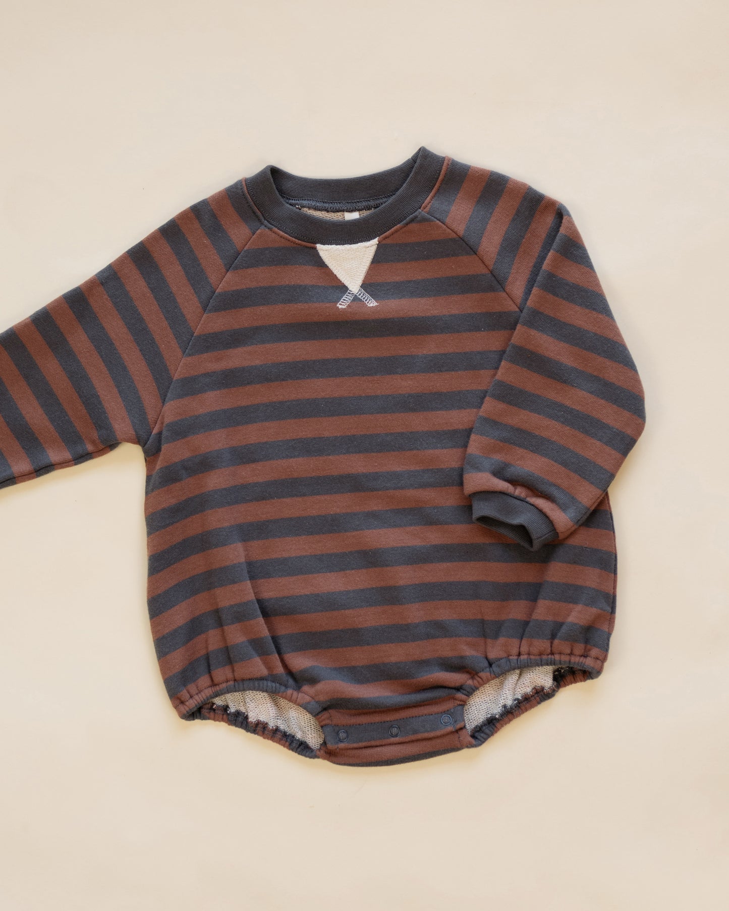 A baby long-sleeve romper with horizontal rust brown and dark gray stripes