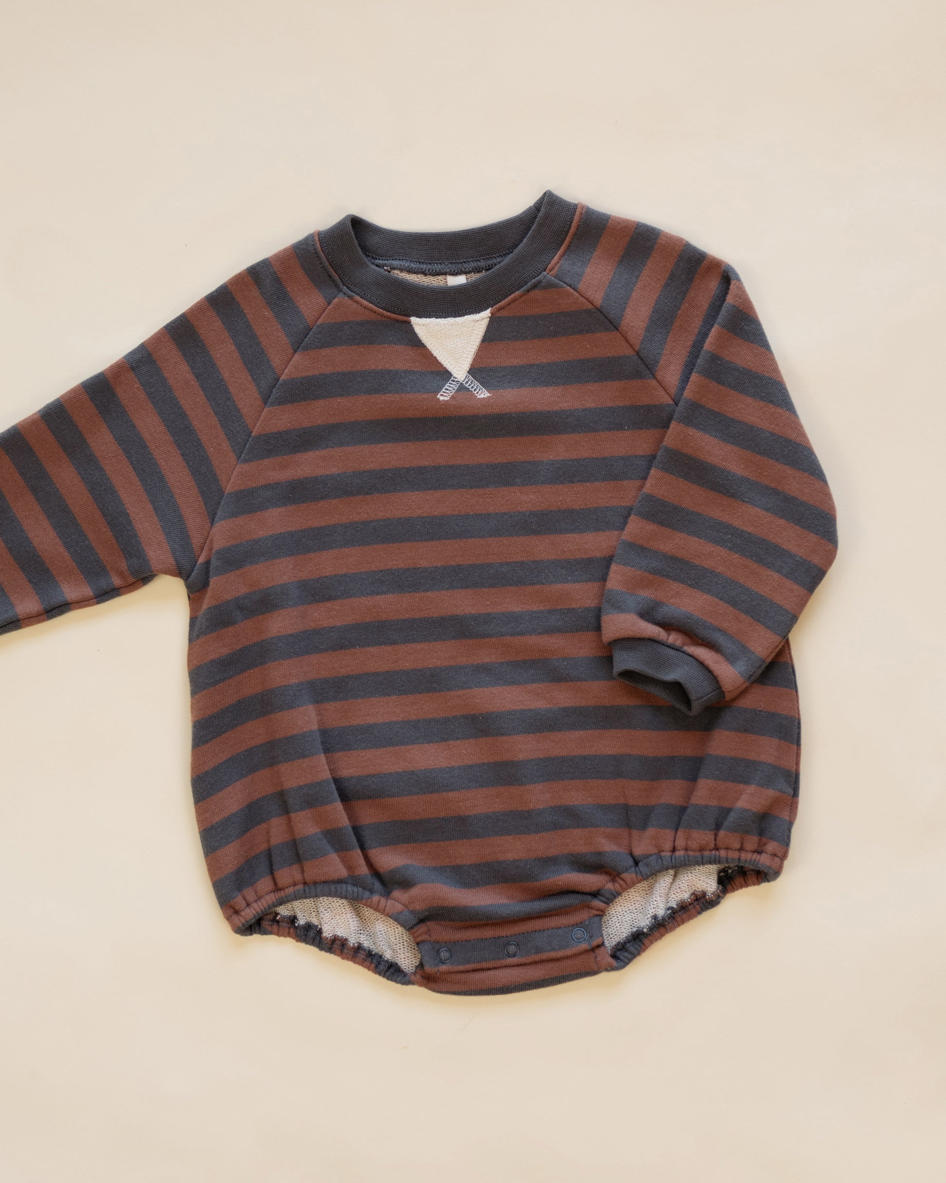 A baby long-sleeve romper with horizontal rust brown and dark gray stripes