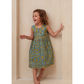 Young girl wearing a floral dress standing against a plain background