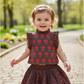 Child wearing a floral dress in a park setting