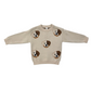 A beige knit crewneck sweater featuring embroidered dog faces in brown, white, and black, displayed flat against a solid white background.