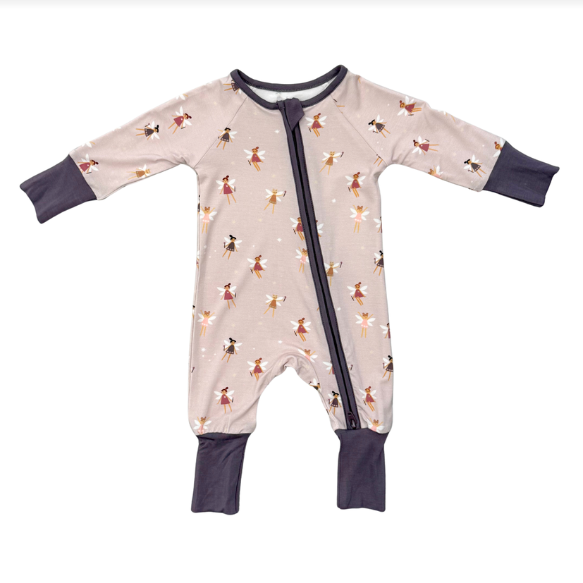 A baby long-sleeve footless sleeper with a front zipper, featuring a light beige background with a pattern of small dancing fairies in red, brown, and white, with dark navy cuffs and leg openings.