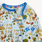 A close-up of a children's long-sleeve pajama top featuring a colorful fantasy castle and dragon print on a light blue base, with a bright blue collar.