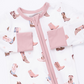 A close-up of a baby romper featuring a white base with a pink zipper and trim, decorated with a pattern of brown and pink cowboy boots.
