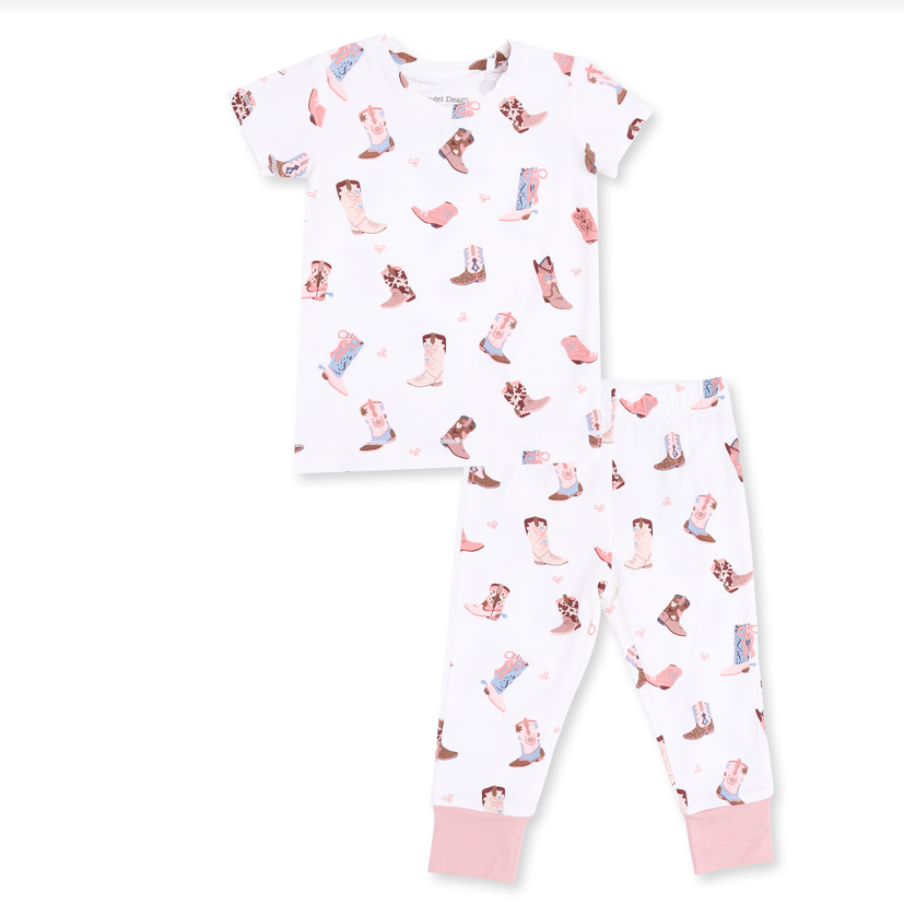 A two-piece children's pajama set featuring a white short-sleeve top and matching pants with an all-over cowboy boot print in pink, brown, and blue, finished with solid pink cuffs.