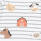 Close-up of a baby garment with horizontal gray and white stripes and embroidered farm-themed motifs including a pig, cow, barn, horse, and sheep.