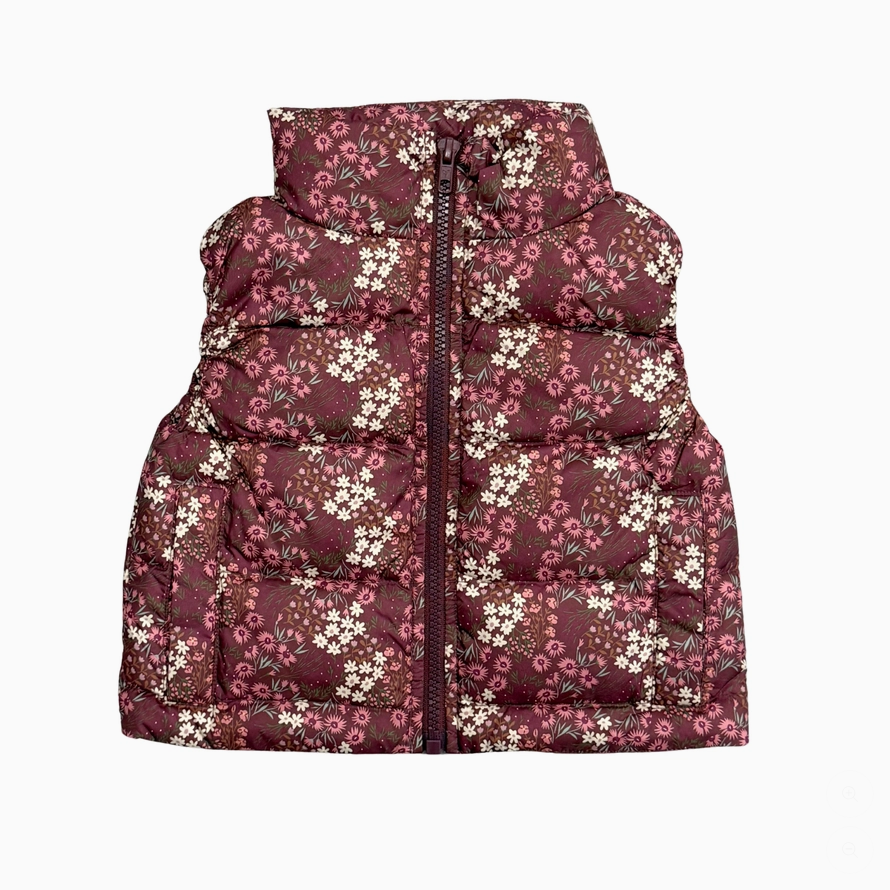 A sleeveless puffer vest with a high collar, featuring a dark burgundy base with a dense white and pink floral print, shown against a plain white background.