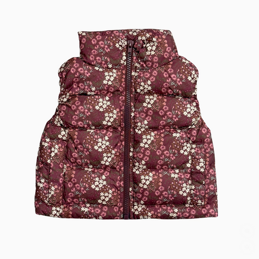 A sleeveless puffer vest with a high collar, featuring a dark burgundy base with a dense white and pink floral print, shown against a plain white background.