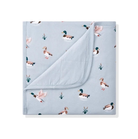 A folded light blue baby blanket or swaddle featuring a printed pattern of mallards and reeds, with one corner folded over to show the soft fabric texture.