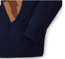 Close-up of a navy blue knit sweater with a brown and tan geometric pattern on the upper chest and ribbed cuffs and hem.