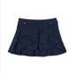 A dark navy blue pleated skirt with a structured waistband, decorative brown buttons, and a layered ruffle design at the front, shown on a plain white background.