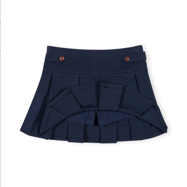 A dark navy blue pleated skirt with a structured waistband, decorative brown buttons, and a layered ruffle design at the front, shown on a plain white background.