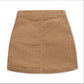 A tan corduroy mini skirt shown from the back, featuring a central seam and a pleated waistband, laid flat against a white background.