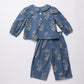 A two-piece baby outfit set consisting of a long-sleeve button-front top with a Peter Pan collar and matching wide-leg pants, both in a dusty blue fabric with a delicate multicolor floral print, laid flat on a light gray background.
