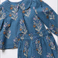 A blue children's outfit set featuring a long-sleeve top with a Peter Pan collar and matching embroidered floral skirt, laid flat on a white background.