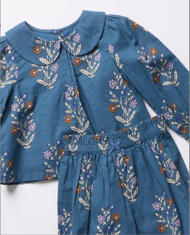 A blue children's outfit set featuring a long-sleeve top with a Peter Pan collar and matching embroidered floral skirt, laid flat on a white background.