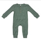 A sage green ribbed knit baby jumpsuit with long sleeves, a buttoned henley neckline, and front patch pockets, shown flat on a white background.