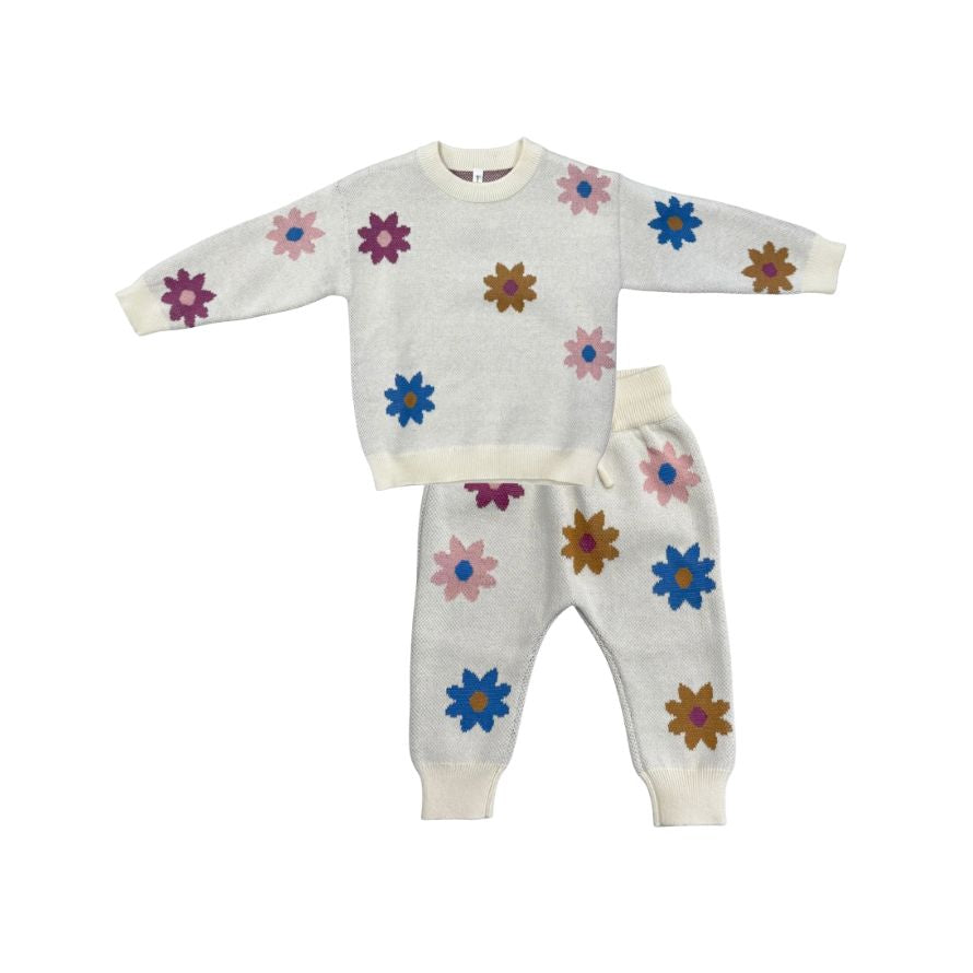 A two-piece children's knit set featuring a long-sleeve top and matching pants in an off-white color, decorated with colorful embroidered flowers in pink, blue, purple, and brown.