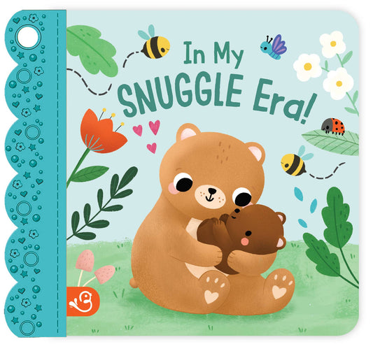 Children's book cover with a bear holding another bear and text 'In My SNUGGLE Era!' on a blue background with flowers and leaves.
