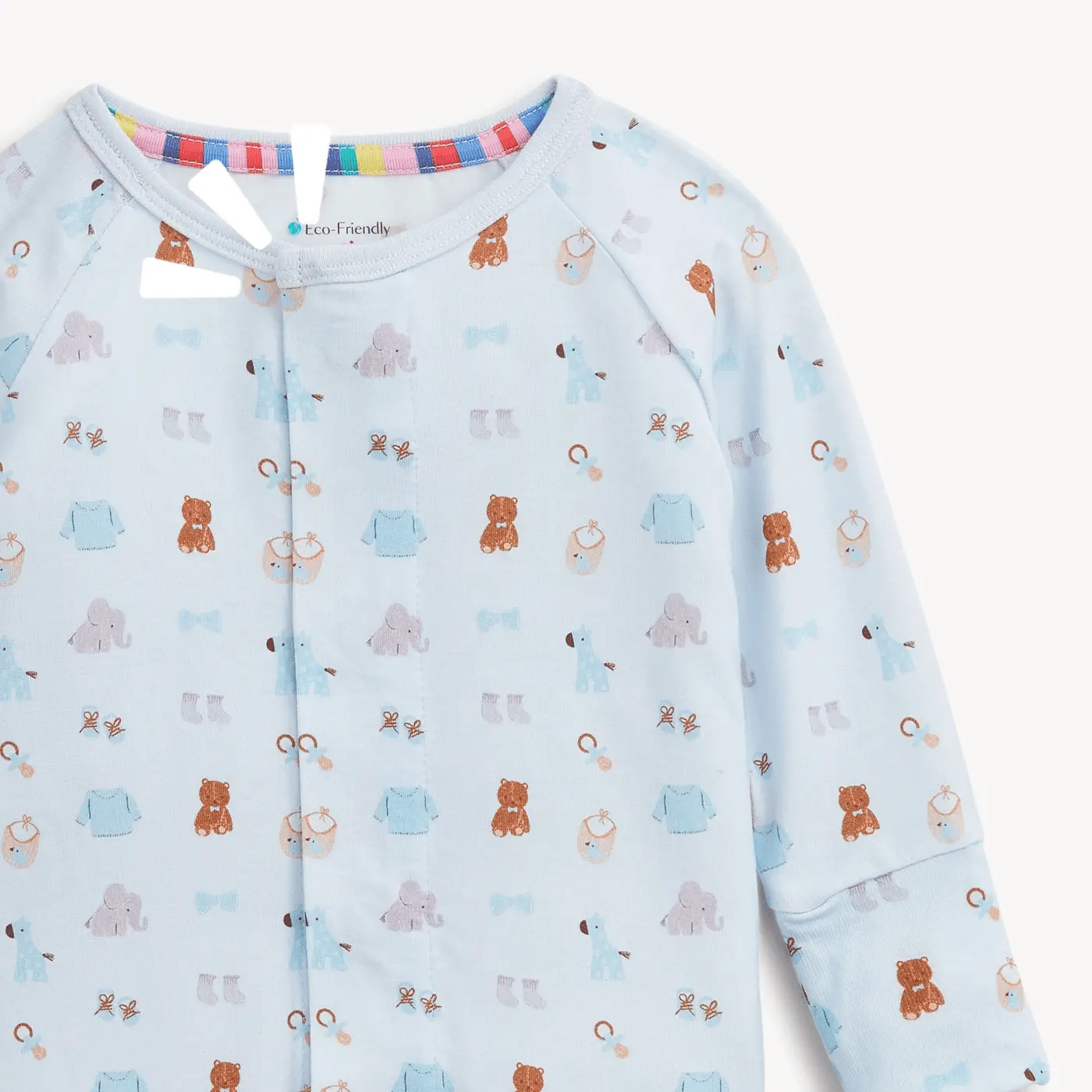 A light blue long-sleeve baby romper with an all-over playful print of teddy bears, bows, and small icons in brown, blue, and lavender. The brand name 'eco Friendly' is visible on the inner neck label.